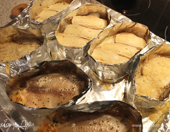 Ставим блюдо в духовку, прогретую до 200 гр., на 20 мин. Перед самой отправкой в духовку выливаем на лист вино между рядами, туда-сюда покачаем его, чтобы вино распределилось равномерно под рис.

Через указанное время достаём рыбу, выкладываем на каждую порцию пластики сыра бри. И запекаем в режиме турбогриль 5 мин.