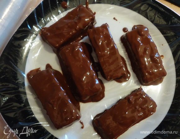 Блюдо или доску выстилаем пищевой пленкой. Быстро окунаем в шоколад со всех сторон кусочки суфле и выкладываем их на пленку. Я это делала руками, потому что суфле довольно нежное, вилка его не берет=)) Потом можно подправить дефекты, полив сверху еще немного шоколадом.