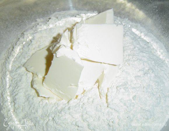 К просеянной муке добавляем сливочное масло, порезанное кусочками, хорошенько перетираем до образование крошки,