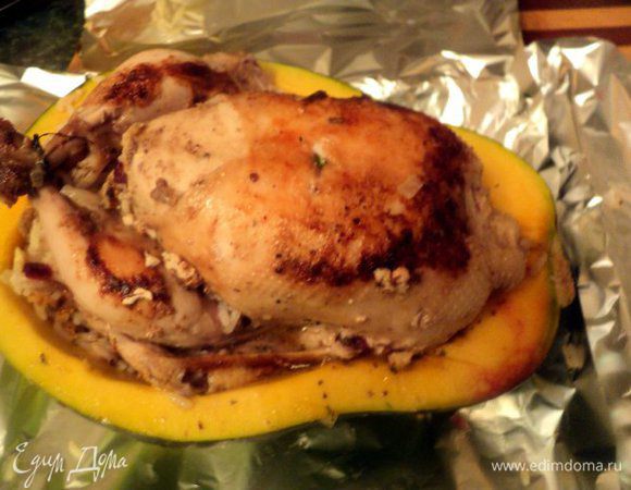 Курицу начинить рисом, крылышки подвернуть, ножки связать. Положить курицу в тыкву, вокруг выложить оставшуюся начинку.