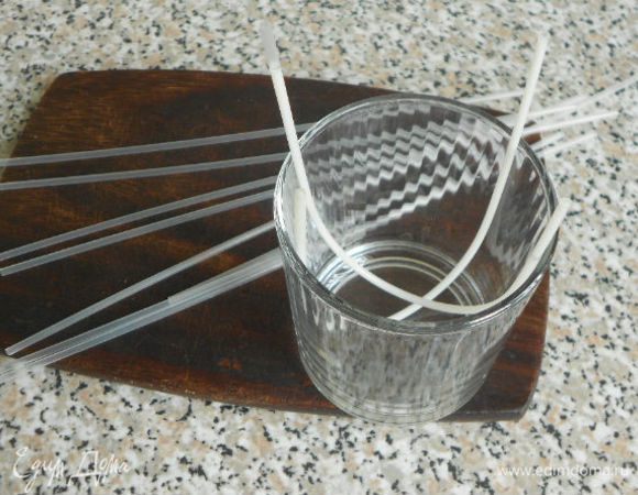 0,5 пакетика бесцветного желе развести молоком вместо воды опять же по инструкции и заполнить тонкие коктейльные трубочки (8 шт. с запасом), охладить и  вытряхнуть содержимое на тарелку. Чтобы содержимое трубочек не вылилось, поместите их в стакан, изогнув. В изогнутом виде опускать на секунду в горячую воду, после чего желе легко выскальзывает из трубочки. Можно, наверное, и расплавленным белым шоколадом из кондитерского мешка украсить, но мне хотелось идеально ровных полосочек добиться, да и побоялась, что шоколад не ляжет на скользкие  бока торта.