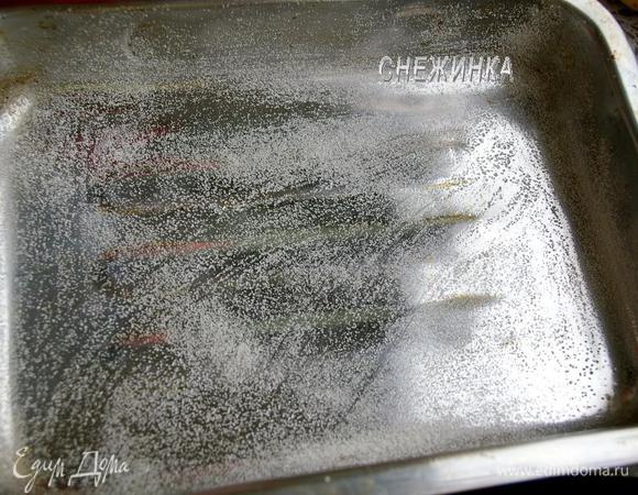 Форму или противень для выпекания (у меня 26×18 см) смазываем маслом и присыпаем манкой. 