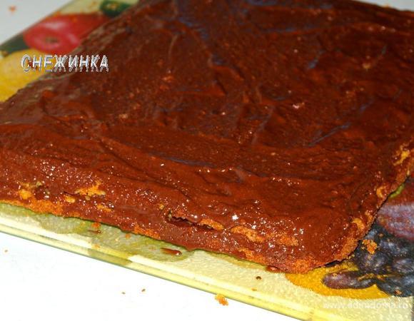 Один корж промазываем половиной помадки, затем накрываем вторым коржом и поливаем оставшейся помадкой. Даём пирогу слегка пропитаться.