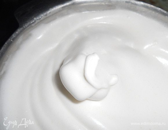 Добавить половину сахара к белкам и взбить до нежных пиков.