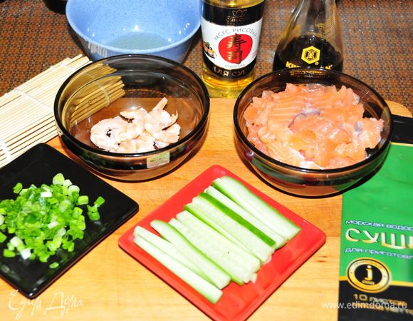 Подготовим все ингредиенты: 
1) Рыбу нарезать тонкими брусочками
2) Креветки окунуть в кипящую подсоленную воду на 2-3 минуты, слить, остудить и почистить
3) Огурец порезать тонкими брусочками
4) Мелко нарезать зелёный лук (достаточно несколько пёрышков)
5) В отдельную мисочку налить рисовый уксус (можно немного разбавить холодной водой) для смачивания рук
