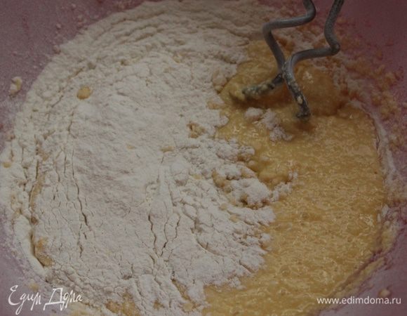Просеять муку с разрыхлителем и частями ввести в масляную смесь.