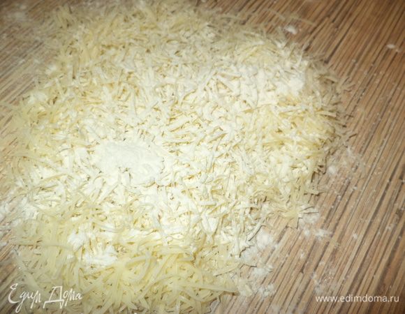 Сыр натереть на терке мелкой сбоку и присыпать слегка мукой, перемешать.