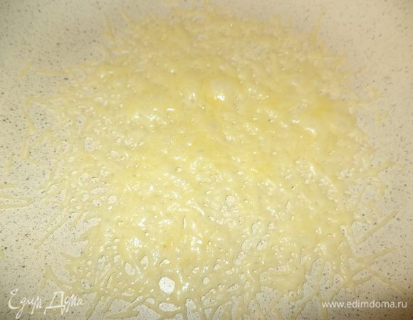 Сковороду с керамическим или другим покрытием нагреть на среднем огне  и присыпать дно сыром, делая серединку поплотнее, а краешки поажурнее. В течение минуты сыр расплавится, сковороду снять с огня на минутку 