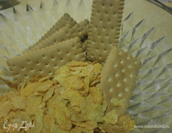 Измельчить в кухонном комбайне печенье и хлопья до состояния мелкой крошки. Добавить сливочное масло.