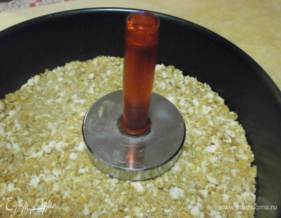 Борт от разъёмной формы диаметром 24 см установить на блюдо. Выложить крошку, тщательно уплотнить и поместить в холодильник на 2 часа.