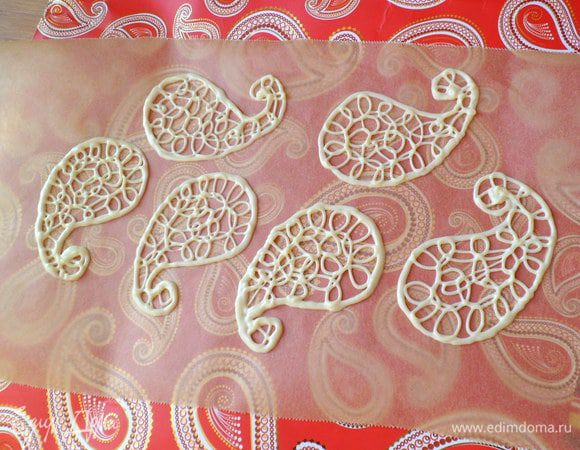 Я взяла пакет с орнаментом пейсли за шаблон, положила сверху пекарскую бумагу и растопив белый шоколад нарисовала фигурки.