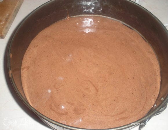 Для начала приготовим бисквит: яйца взбиваем с сахаром до загустения массы и увеличения в объеме в несколько раз. Осторожно добавляем просеянную муку, какао, разрыхлитель, вымешиваем. Добавляем кипяток, растительное масло, осторожно перемешиваем и выливаем тесто в форму застеленную пергаментом. Выпекаем 25-30 минут при темп. 180 гр.