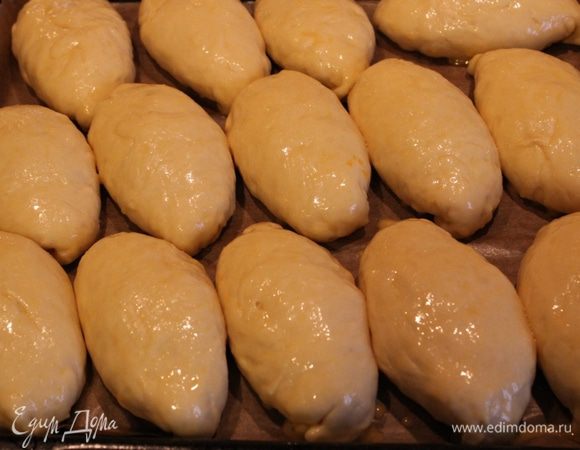 Смажьте пирожки взбитым яйцом.