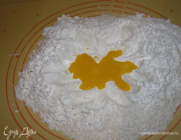  Сделайте углубление внутри, вылить желтки и добавить сливочное масло, порезанное кусочками,быстро замесить тесто.