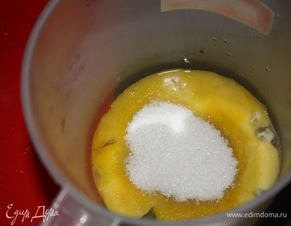 Желтки смешиваем с оставшимся сахаром и взбиваем миксером.