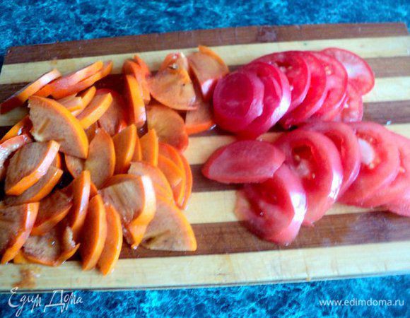 Помидоры и хурму порезать тонкими пластинками. Салат порвать руками на кусочки, оставив несколько листочков для украшения.