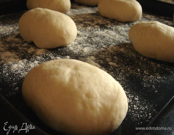 Тесто разделить на маленькие кусочки (по 60 г) и сформовать овальные булочки. Выложить на присыпанный мукой противень наши булочки, прикрыть полотенцем и оставить на расстойку на 30 минут.