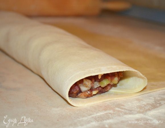 Аккуратно закручиваем в рулет и переносим на противень, застеленный ковриком для выпечки. 