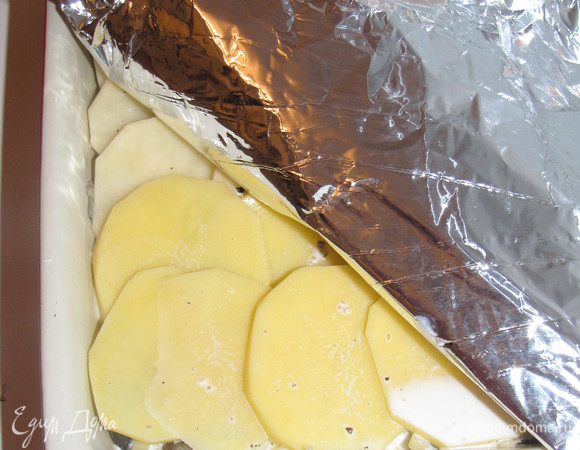 Влить смесь сливок и вина. Закрыть фольгой и поставить в духовку, разогретую до 200 град.на 40 минут. Затем фольгу снять, посыпать сыром и запекать еще 40 минут. Перед подачей накрыть и дать постоять  25 мнут.
