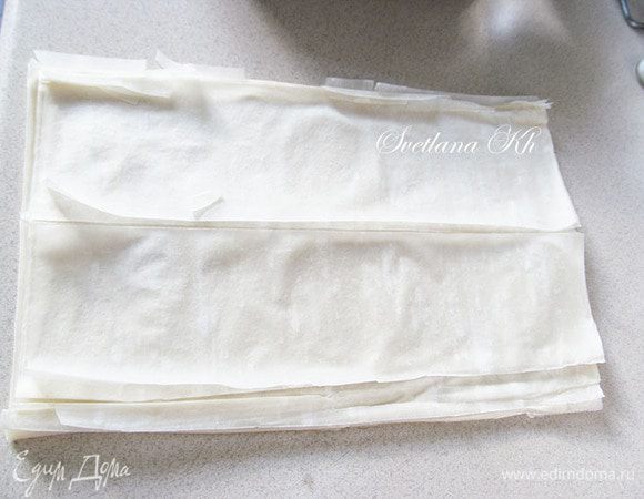 Орехи крупно порубить, я ломаю их руками. Изюм замочить в горячей воде, промыть и обсушить. Несколько листов теста отделить от общей пачки. остаток снова упаковать, чтобы тесто не сохло.