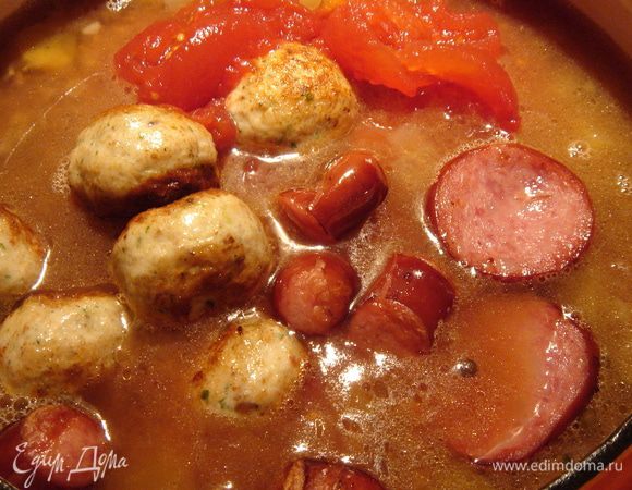 Томаты,тефтели и колбасу переложить в кастрюлю с супом,посолить поперчить и добавить перетёртые специи,прикрыть суп крышкой и довести до готовности.  В готовый суп добавить мелко нарезанные перья зелёного лука. Приятного аппетита!