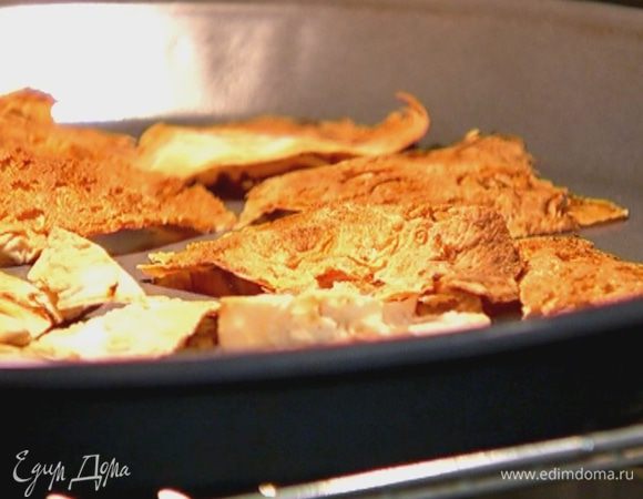 Лаваш нарезать небольшими треугольниками, выложить в противень и отправить под гриль на 1–2 минуты.