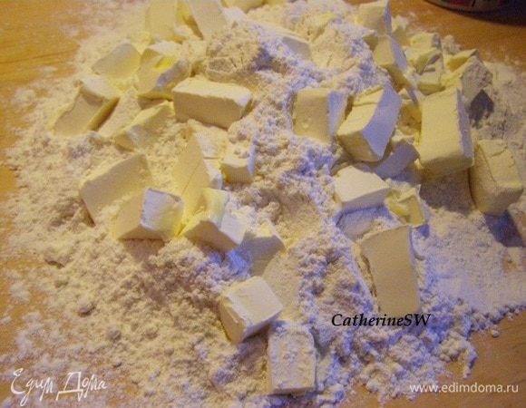 Муку смешайте с содой и солью, просейте горкой на доску. Маргарин нарежьте кусочками, положите на муку. Порубите ножом муку и маргарин, чтобы все превратилось в мелкую крошку.