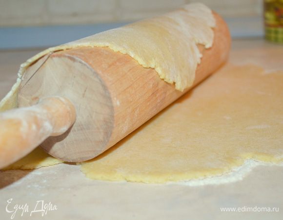 Раскатываем тесто в круг и с помощью скалки переносим на коврик для выпечки.