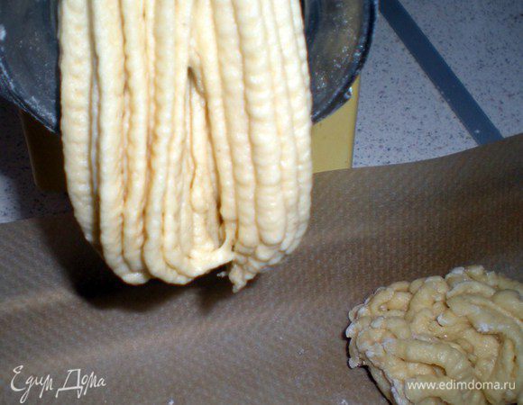 Подготавливаем противень застеленный пергаментом. Ножницы. Включаем мясорубку  и быстренько отрезаем выползающее тесто, по размеру нужного нам печенья. Сразу выкладываем на противень.