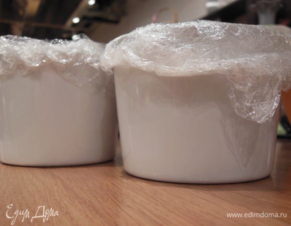 Креманку изнутри покрыть пищевой пленкой, оставив края. Залить наполовину яично-сырной массой.