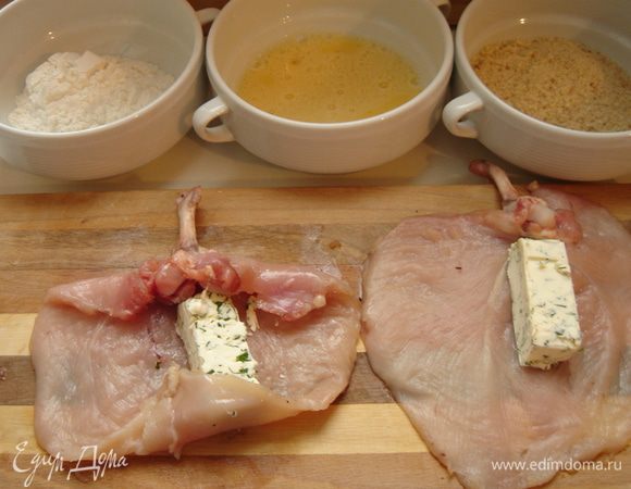 Масло разделите на два брусочка и выложите на край филе. Подверните края филе так, чтобы косточка торчала наружу. Сверните отбитое филе в рулет.