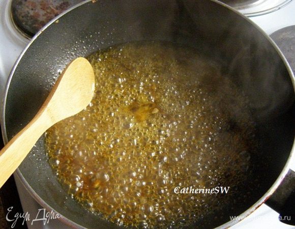 В сковороде растопить масло, высыпать в него сахар, перемешать, добавить лимонный и апельсиновый соки, апельсиновую цедру, уварить до карамелизации сахара.