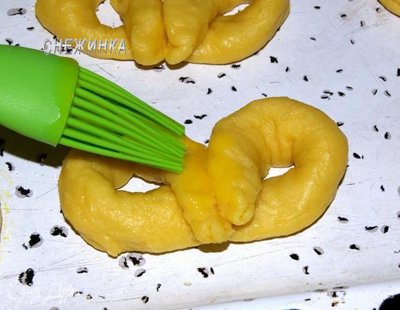 Крендели выложите на противень. Смажьте взбитым яйцом.