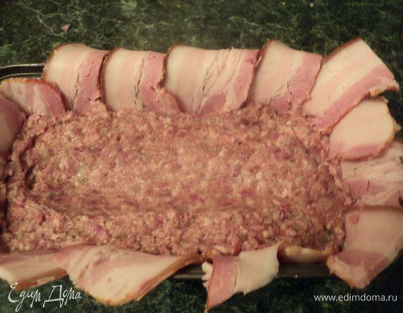 В форму плотно выложить половину фарша, несколько раз постучать формой, чтобы смесь еще более уплотнилась. Посередине сделать небольшое продольное углубление.