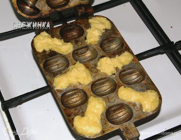 Теперь можно приступить к выпечке грибочков. Форму в закрытом виде положите на огонь, чтобы она разогрелась. Переверните и прогрейте также с другой стороны. Снимите с огня и смажьте выемки для грибочков растительным маслом при помощи кисточки или салфетки, смоченной в масле. Чайной ложкой положите тесто в выемки, заполняя их полностью. Накройте второй половиной формы и поставьте на средний огонь. Готовьте с одной стороны около 4 минут, затем переверните и держите на огне с другой стороны столько же. Первые несколько партий жарятся дольше, но после выпечки со второй стороны нужно смотреть, приоткрыв форму, возможно, потребуется еще раз перевернуть. Важно не передержать!