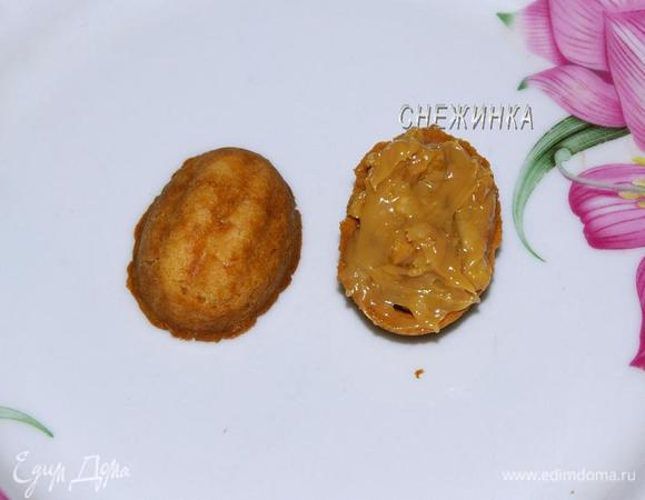 Когда половинки остынут, смажьте одну сгущенкой, соедините со второй половинкой. Сформируйте оставшиеся орешки.