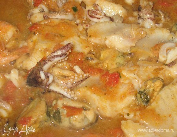 В кастрюле с кипящей водой бланшировать помидоры, вынуть их,снять кожицу, удалить семена и сок, крупно нарезать мякоть. В сковороде разогреть оливковое масло, подрумянить слегка раздавленный зубчик чеснока и  удалить   (он нужен только для аромата). Добавить помидоры, посолить, поперчить. Готовим все это минут 5  на небольшом огне. Добавить морепродукты и  готовить 10 мин. 