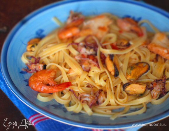 Пасту отварить согласно инструкции на упаковке. Откинуть на дуршлаг, выложить в сковородy с морским коктейлем и соусом, перемешать, прогреть 1 минуту, разложить по тарелкам и подать с белым вином. 