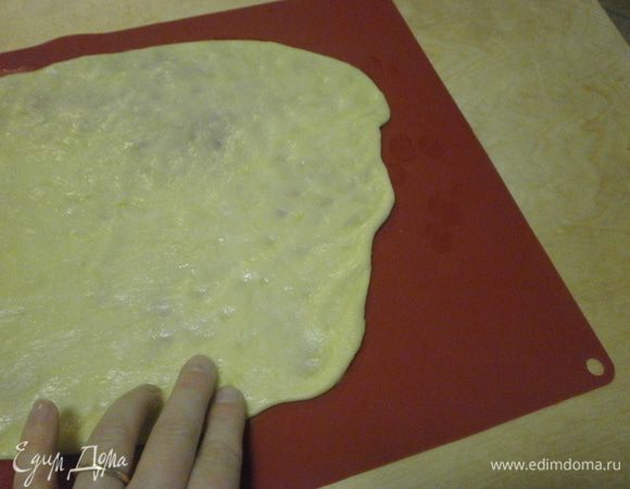 дальше нам потребуется для работы мраморная поверхность стола или силиконовй коврик. Деревянная поверхность не подойдёт, быстро впитывает жидкость.Я использую коврик, очень удобно. Выкладываем тесто в центр коврика и начинает постепенно расминать тесто, растягивая  по направлению к краям коврика. Тесто очень эластичное, мягкое, с ним приятно работать.