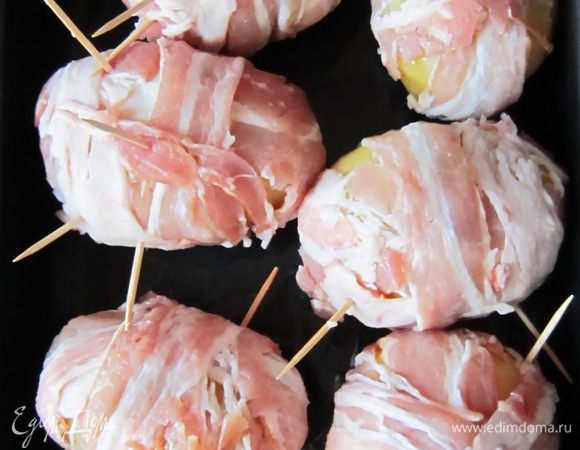 Соединить половинки картофеля, обернуть в бекон и закрепить зубочистками. 
Подготовленные картофелины уложить на смазананный растительным маслом противень и поставить в разогретую до 180гр духовку на 30мин.