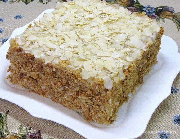 Собираем торт:
у коржей подровнять края, из обрезков приготовить крошку. Уложить друг на друга, намазывая кремом. Если торт получился слишком высоким, можно не надолго поставить под пресс. Затем обильно смазать кремом верх и бока торта, посыпать подготовленной крошкой (у меня сверху миндальные лепестки). Перед подачей к столу выдержать в холодильнике 4-5 часов.