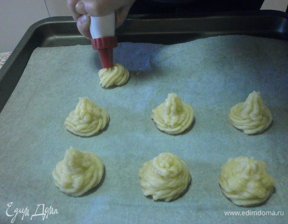 Готовый рулет переложить в другую посуду и держать в теплой духовке.
Картофель помыть, отварить, очистить. Размять в пюре. Добавить один желток, соль и мускатный орех. Выложить массу в кондидерский мешок и отсадить " розочками" на лист,застеленный бумагой и смазанный сливочным маслом.Смазать произвольно желтком с помощью кисточки. запечь в духовке, пока " лепестки" не приобретут золотистый цвет.