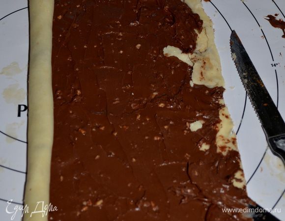 Второй кусок теста смажем шоколадной пастой, посыпем орехами и также свернем рулетом.