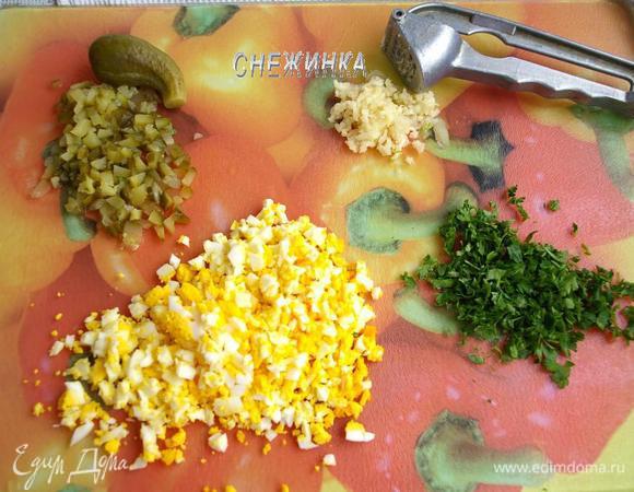 Мелко нарезаем маринованный огурчик. У меня свои, маринованные по-болгарски. Измельчаем варёные яйца, зелень. Чеснок чистим, пропускаем через пресс.