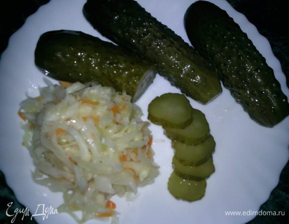 Квашеную капусту приправить растительным маслом и добавить немного мелко нарезанного лука. Маринованные огурцы нарезать кольцами. Огурцы и капусту разложить на тарелке.