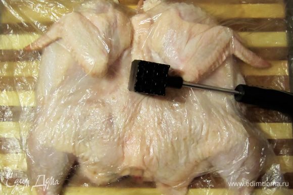 Цыпленка уложить спинкой вверх, накрыть целлофаном и слегка отбить молоточком.