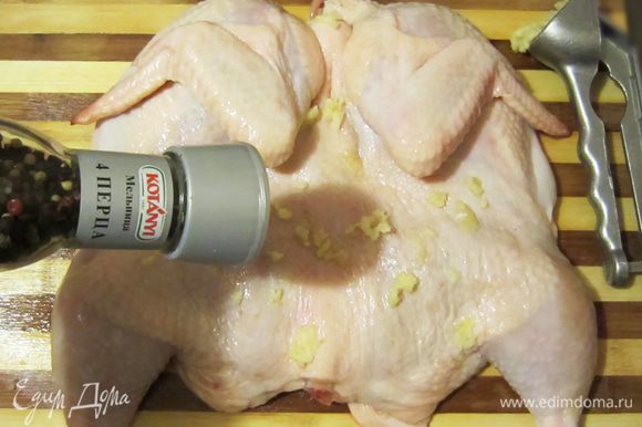 Чеснок очистить и измельчить с помощью чеснокодавилки. Натереть цыпленка внутри и снаружи солью, чесноком, приправить перцем.
