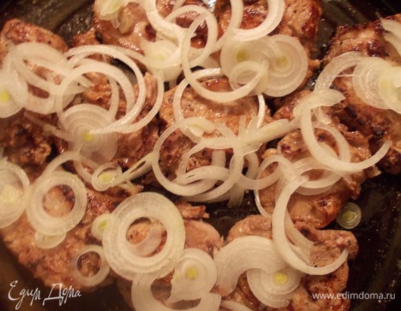 Порезать лук тоненькими кольцами и уложить сверху мяса.