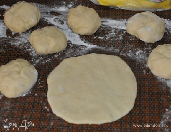 Отщипываем аккуратно кусочек теста, выкладываем на припыленный мукой стол. Остальное тесто подходит дальше. Работаем с кусочком. Больше не месим. Осторожно, нежно делим его на порции, обваливаем в муке. В отдельной кастрюльке растапливаем масло для начинки. В чашечке смешать сахар и корицу.