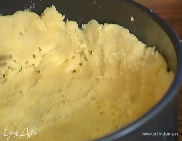 Руками сформировать из теста шар и равномерно распределить его по разъемной форме для выпечки, сделав высокие бортики. Часто наколоть тесто вилкой и отправить форму в морозильник.